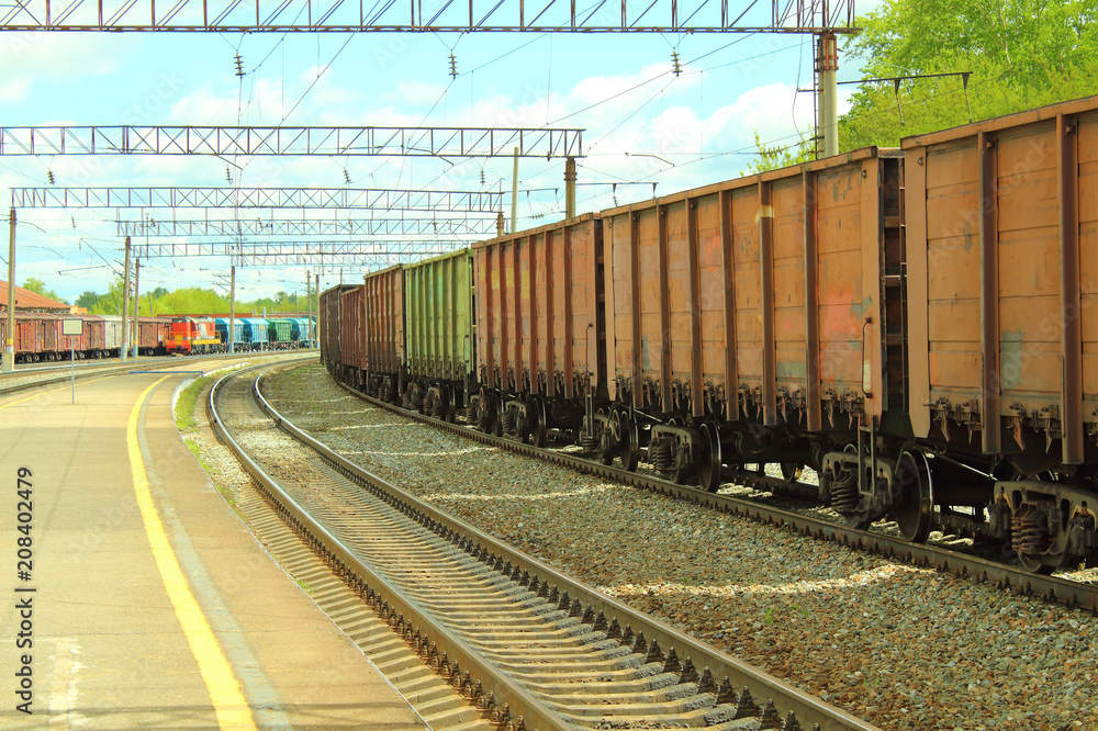 Freight railroad cars at the station. The train on the rails. Close-up. Freight railroad cars at the station. The train on the rails. Close-up.