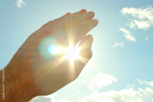 Fotografie, Obraz A man's hand covers a bright scorching sun