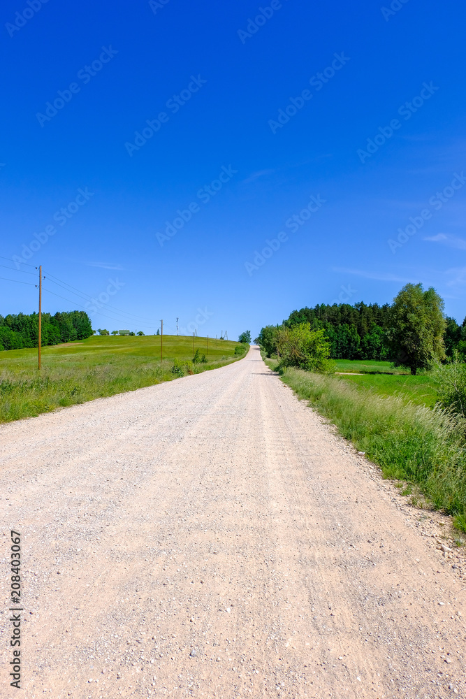 empty gravel road in the countryside in summer heat