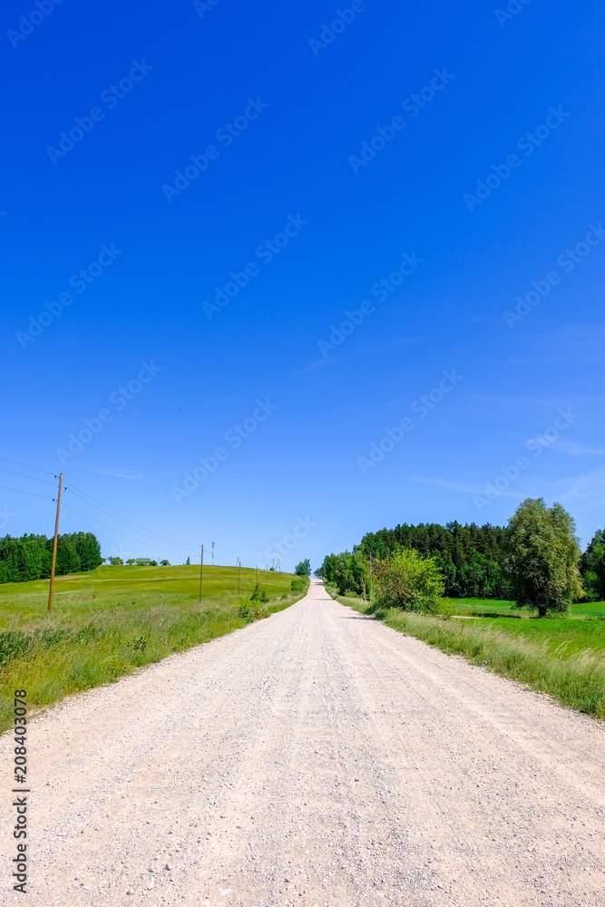 empty gravel road in the countryside in summer heat