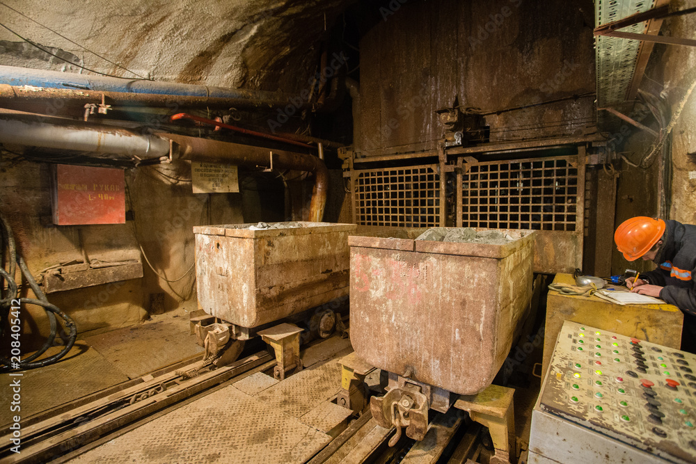 Underground emerald ore mine shaft tunnel gallery with light and wagons
