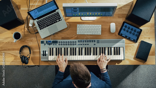 Bild auf Leinwand Top View of a Musician Creating Music at His Studio, Playing on a Musical Keyboard
