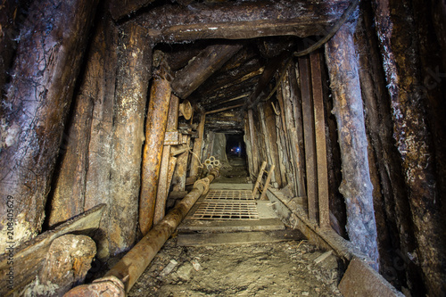 Underground emerald ore mine shaft tunnel gallery with timbering © Mishainik