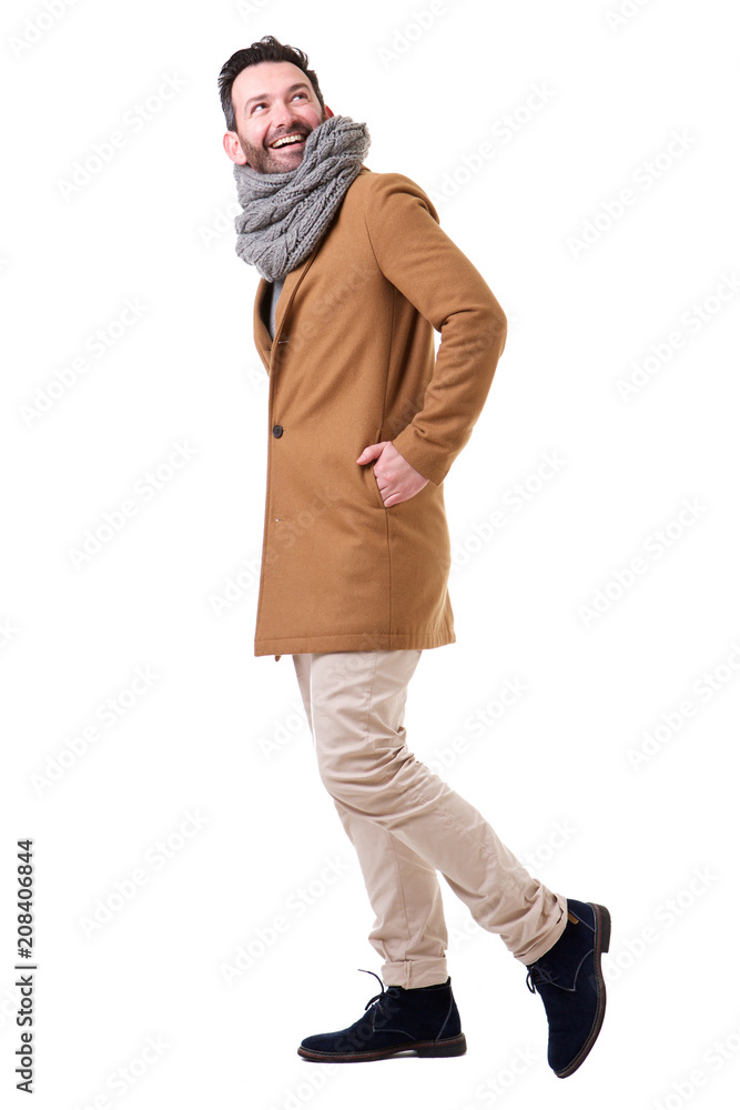 Full length side of man walking with coat and scarf against white background Full length side of man walking with coat and scarf against white background