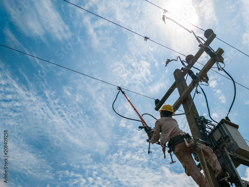 The power lineman closing a transformer on energized high-voltage electric power lines.