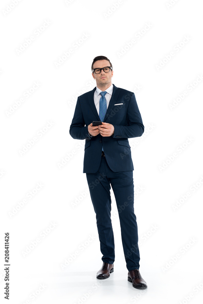 full length view of confident buisnessman in eyeglasses holding smartphone and looking at camera isolated on white full length view of confident buisnessman in eyeglasses holding smartphone and looking at camera isolated on white