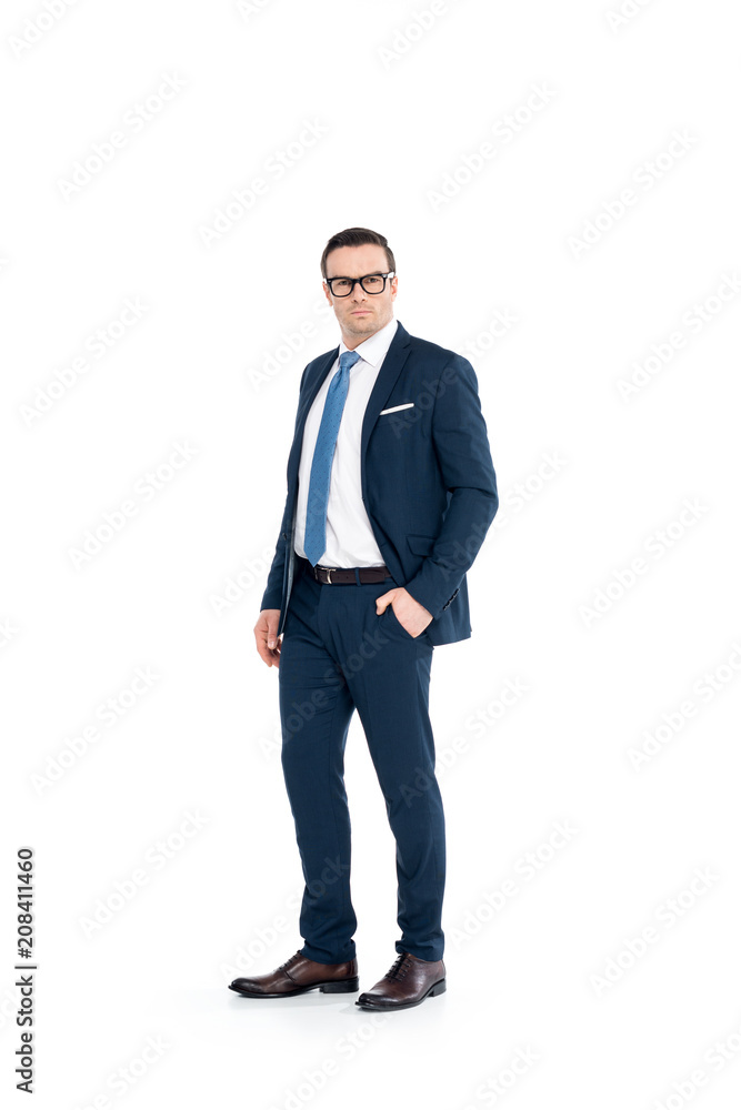 full length view of confident businessman in eyeglasses and suit standing with hand in pocket and looking at camera isolated on white full length view of confident businessman in eyeglasses and suit standing with hand in pocket and looking at camera isolated on white