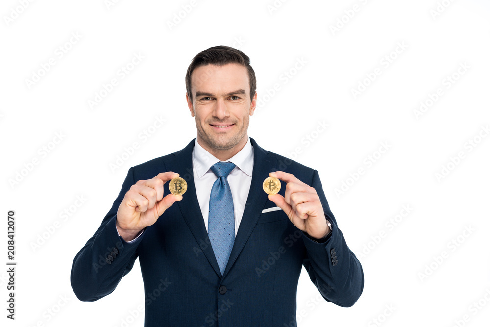 handsome middle aged businessman holding bitcoins and smiling at camera isolated on white handsome middle aged businessman holding bitcoins and smiling at camera isolated on white