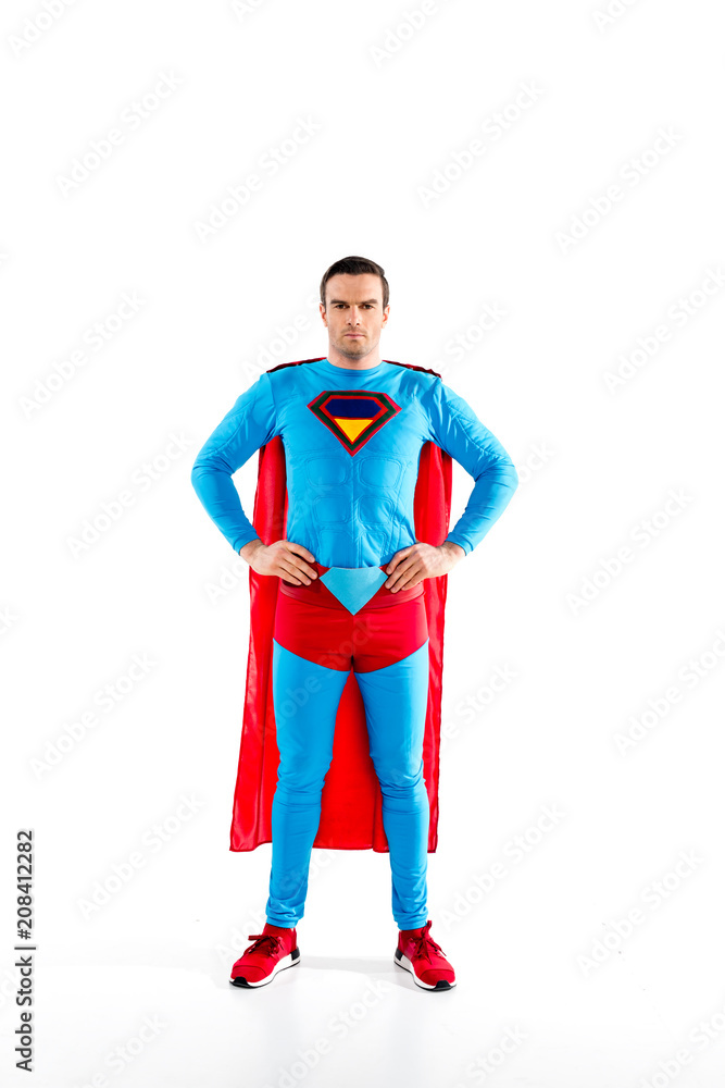 full length view of handsome mid adult superman standing with hands on waist and looking at camera isolated on white full length view of handsome mid adult superman standing with hands on waist and looking at camera isolated on white