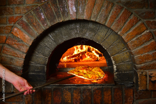 Pizza yolo with pizza near the stone stove photo