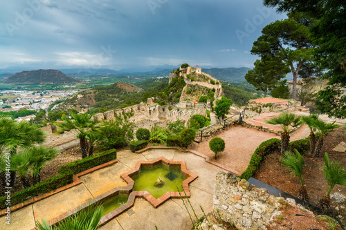 The medieval castle of Xativa against a dramatic and bright sky after the rain. District of Valencia. Spain photo