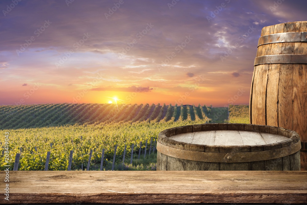 Red wine with barrel on vineyard in green Tuscany, Italy