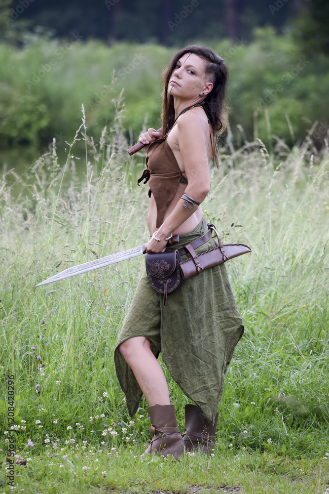 beautiful Celtic warrior woman with ax and sword in the field Stock ...