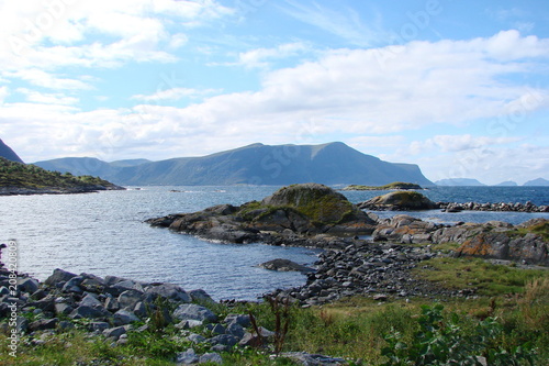 landscape of the coast of the Norwegian Sea against the background of a cloudy blue sky.