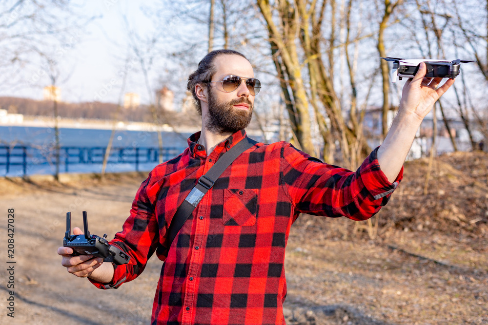 guy starts a quadrocopter in the park, a close view guy starts a quadrocopter in the park, a close view