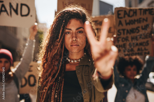 Woman showing a peace sign during protest