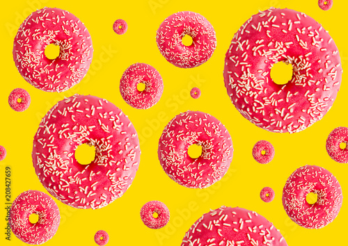 Pink donuts isolated on yellow background. Top view.