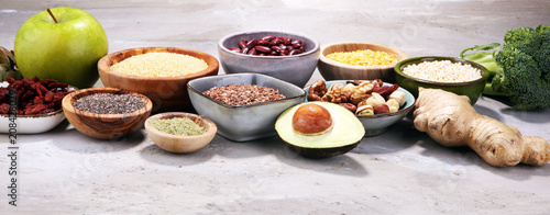 superfood concept on stone table with avocado, goji and nuts and seeds.