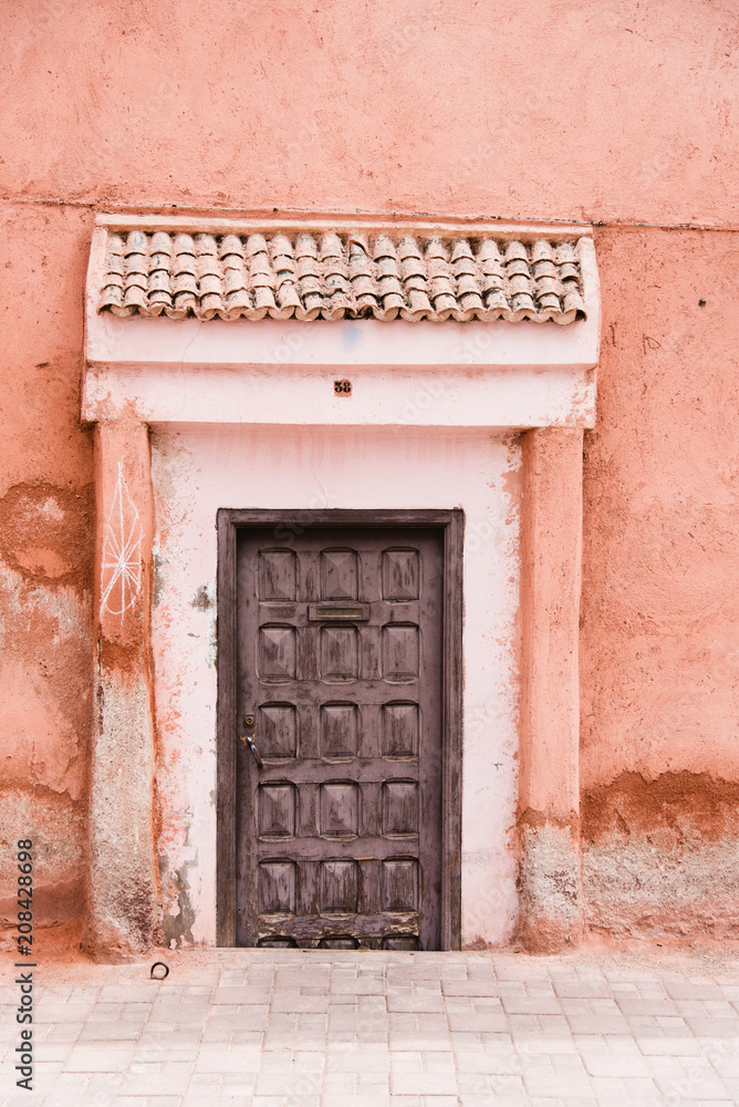 Old Wooden Door with Terracotta Pink Stone Wall, Marrakech, Morocco Old Wooden Door with Terracotta Pink Stone Wall, Marrakech, Morocco