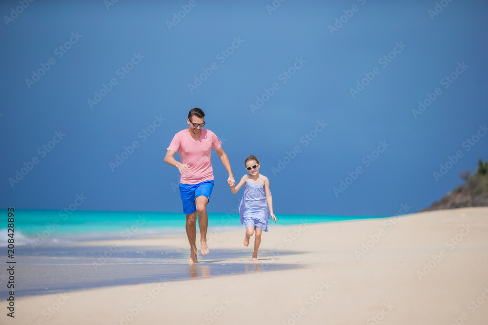 Family of father and sporty little girl having fun on the beach
