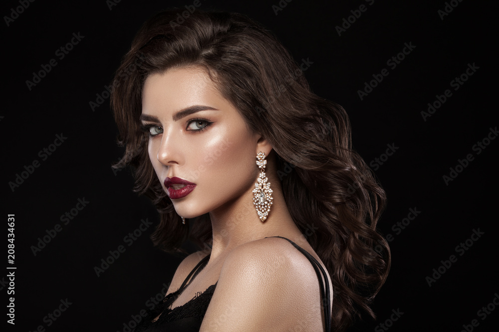Naklejka premium Fashion glamorous portrait of a girl on a dark background. Elegant hairstyle, bright makeup and lip color. Hollywood picture.