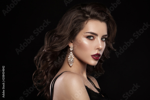 Fashion glamorous portrait of a girl on a dark background. Elegant hairstyle  bright makeup and lip color. Hollywood picture.