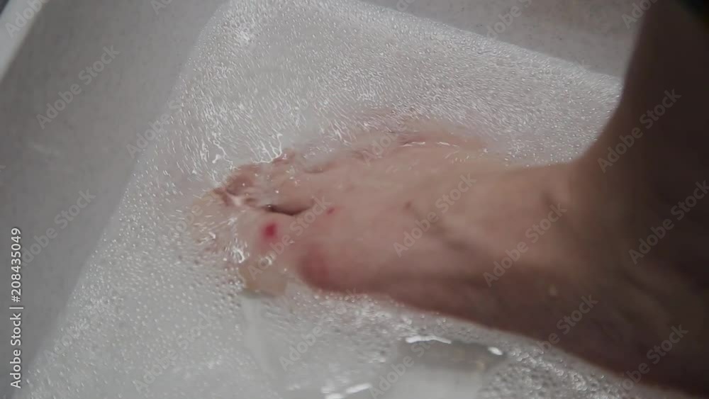 Woman washes her feet in soapy water. Woman washes her feet in soapy water.