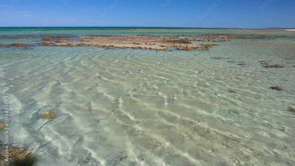 A wide shot of rocks and ocean with horizon and sky. A wide shot of rocks and ocean with horizon and sky.