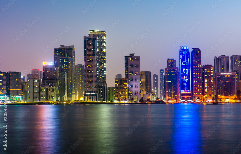 Naklejka premium Sharjah waterfront cityscape in UAE at blue hour