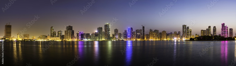 Panoramic view of Sharjah waterfront cityscape in UAE at dusk Panoramic view of Sharjah waterfront cityscape in UAE at dusk