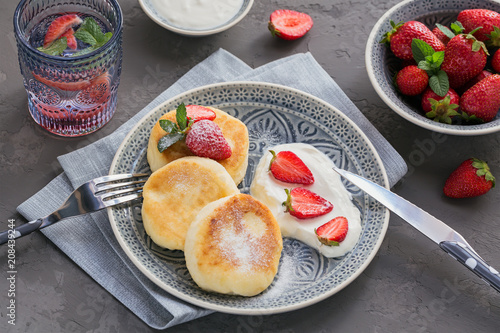 Cottage cheese pancakes with sour cream and strawberries for breakfast or lunch