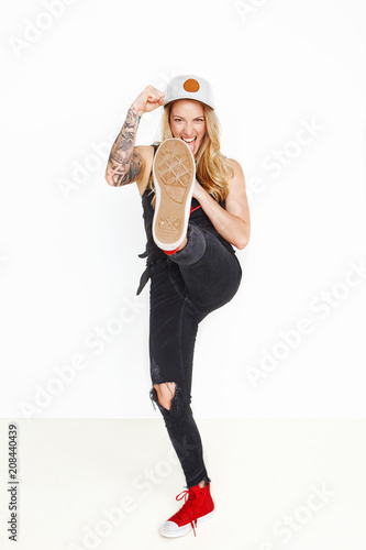 Cool girl goofing around throwing hat at camera on a white background, copy space