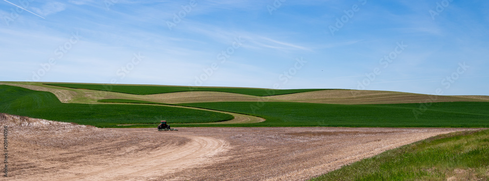 Tractor on fields in the Palouse under bright sky