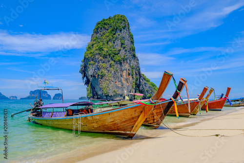 Beautiful landscape with long tail boats on tropical beach of island Krabi, Thailand.