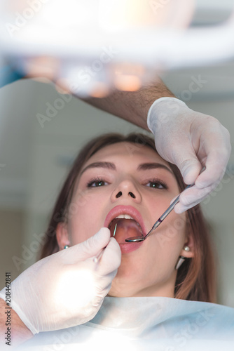 doctor orthodontist examines the oral cavity of a beautiful patient