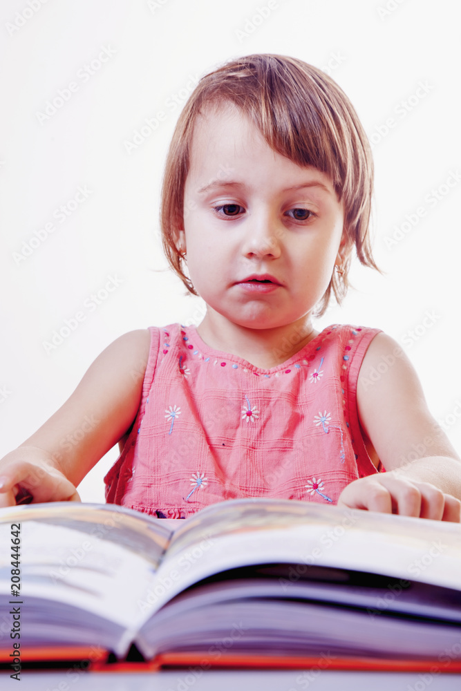 Cute little child girl is reading a book (science, development, education concept) Cute little child girl is reading a book (science, development, education concept)