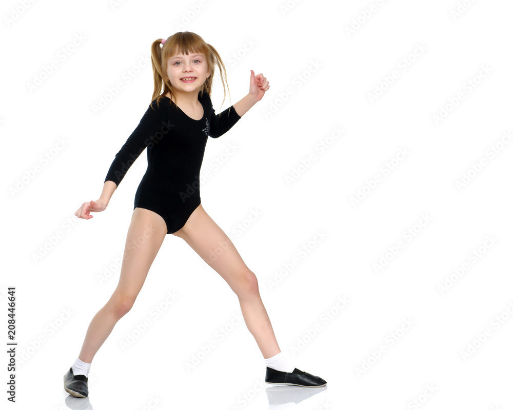 A little girl does gymnastic exercises. A little girl does gymnastic exercises.