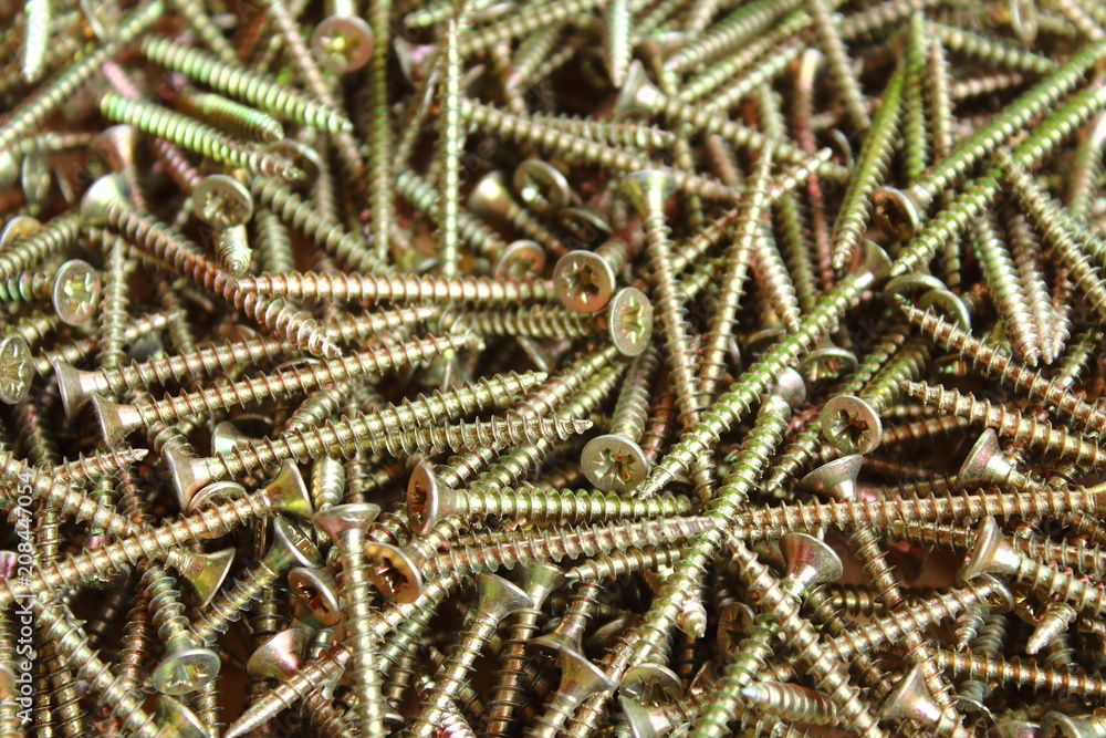 Small silver screws. Close-up. Texture. Background. Small silver screws. Close-up. Texture. Background.