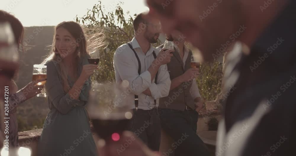 Young multi-ethnic friends drinking wine and beer at rustic party Young multi-ethnic friends drinking wine and beer at rustic party