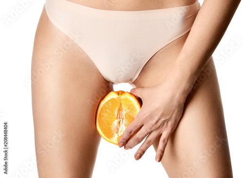 body care gynecology and woman's health. Close up photo of woman hand hold orange fruit near Intimate part photo