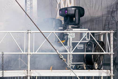 professional spotlights and smoke machine on street stage before concert