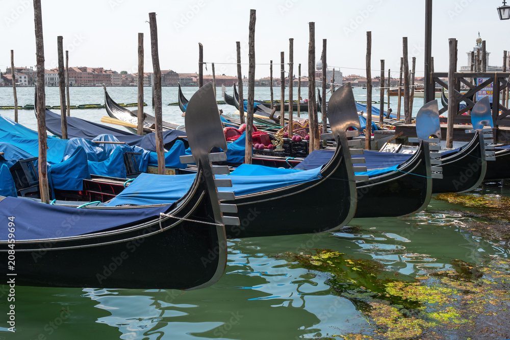 Gondolas in Venice. The gondolas are moored at the mooring posts. Venice, Italy.