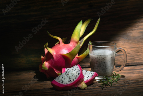 Healthy dragon fruit smoothie in mug over a rustic wood background
