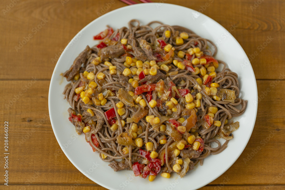Soba noodles with beef, corn, onions and sweet peppers. Top view Soba noodles with beef, corn, onions and sweet peppers. Top view