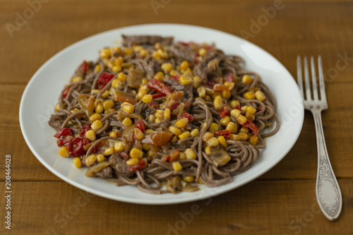 Soba noodles with beef, corn, onions and sweet peppers. Top view