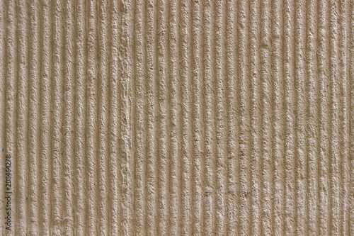 Light beige wall with decorative plaster vertical stripes.