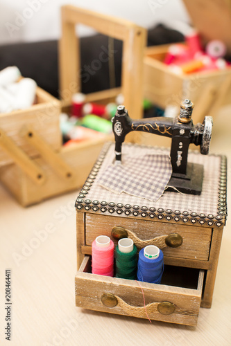 Sewing threads multicolored in wooden box background closeup