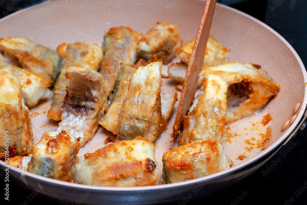 Pieces of fish fried in a hot pan Pieces of fish fried in a hot pan