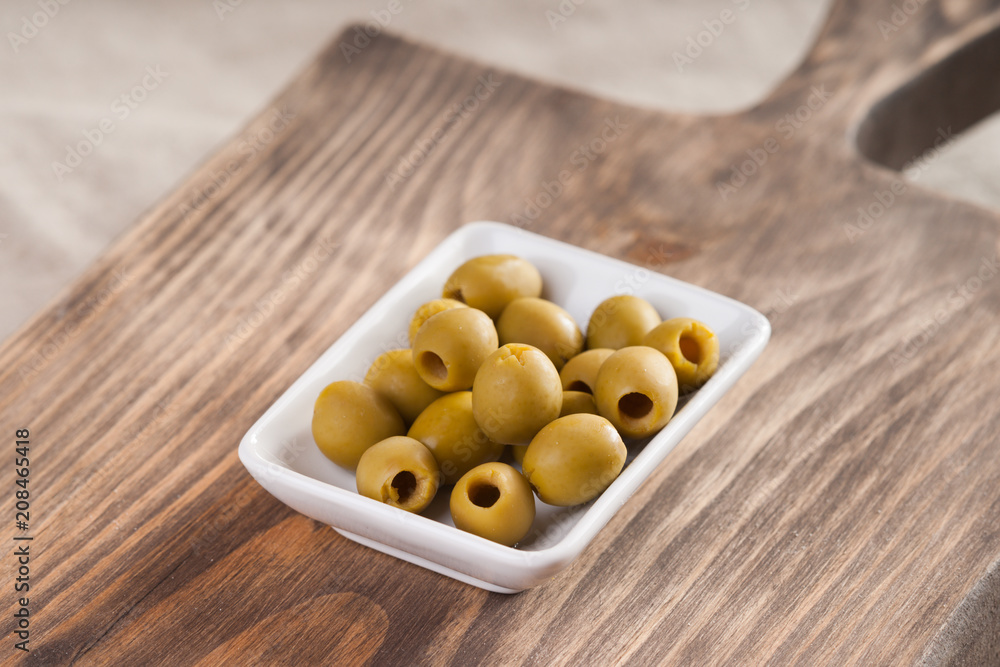 Olives in a bowl on wooden surface Olives in a bowl on wooden surface