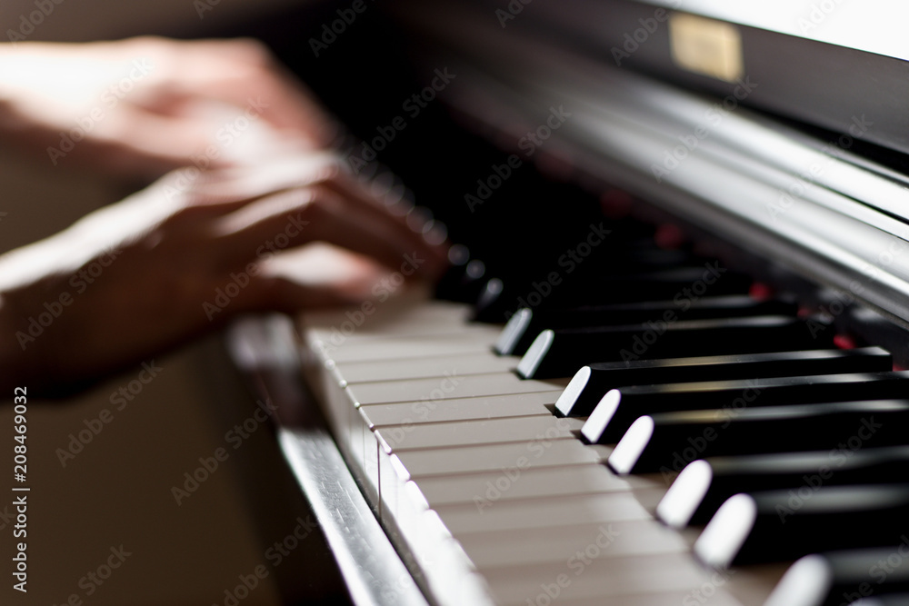 Obraz premium Classic shiny piano keyboard with pianist player hands playing in background